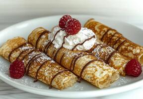 crepes with chocolate sauce, whipped cream, and raspberries photo