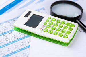 work with a magnifying glass, a calculator and papers photo