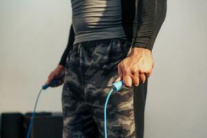 Workout session featuring a person using a jump rope in a gym setting during early morning hours photo