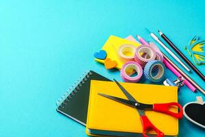 Crafting supplies laid out on a vibrant blue background for creative projects and DIY activities photo
