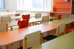 Bright and colorful classroom with neatly arranged tables and chairs in a learning environment designed for creativity photo