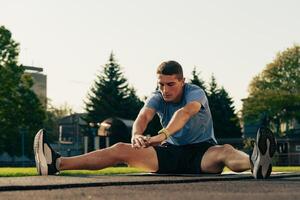 Man performs stretching exercises outdoors in a park during early morning hours for fitness and flexibility photo