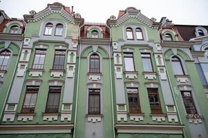 historical green building built in 1905. the wall of the building faces the street gothic-style building. close-up of the building. photo