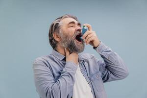 Senior Man Using Asthma Inhaler for Breathing Problems photo