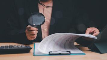 Analyzing Data for Insights, professional examines documents with magnifying glass, highlighting attention to detail and meticulous analysis in data review processes photo