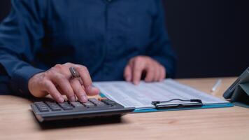 Crunching Numbers with Precision, Focused individual works on calculations using calculator, highlighting importance of accuracy in financial tasks photo