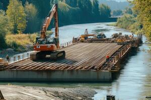 Construction crew builds bridge foundation over river with heavy machinery during sunny day photo