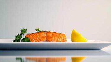 Freshly cooked salmon garnished with herbs and lemon served on a white plate in a minimalist setting photo