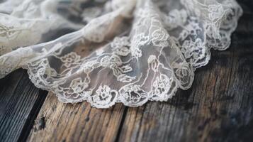 Delicate lace fabric resting on weathered wooden surface with intricate patterns and texture in soft natural light photo