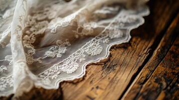 Delicate lace fabric draped over rustic wooden surface in soft lighting photo