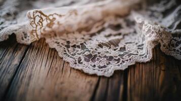 Delicate lace fabric draping gracefully over rustic wooden surface in soft natural light photo