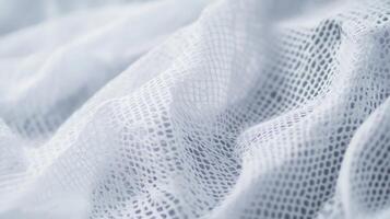 Soft white mesh fabric draped elegantly, showcasing its delicate texture and airy quality in natural light photo