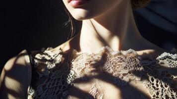 Light and shadow play on the neckline of a woman wearing delicate lace in a dimly lit space photo