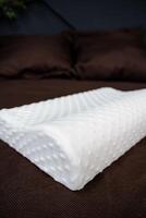 A white pillow on a bed with brown pillows photo