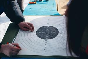 A person is pointing to a target on a paper photo