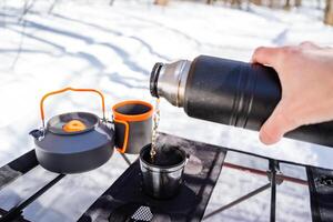 A person pours hot water into a coffee pot photo