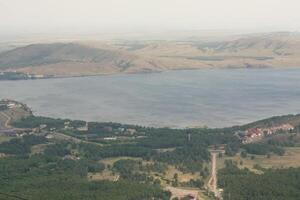 An aerial view of a lake and mountains photo