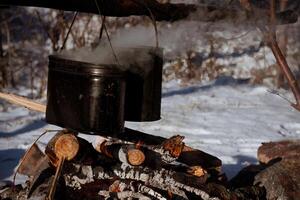 A pot of boiling water is sitting on top of a fire photo