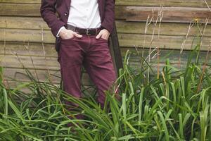 A man in a suit standing in a field of tall grass photo