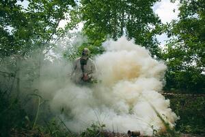 A man in a gas mask standing in a field of smoke photo