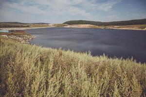 A large body of water with a boat in the middle photo