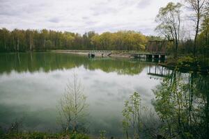 A lake with a bridge and trees in the background photo