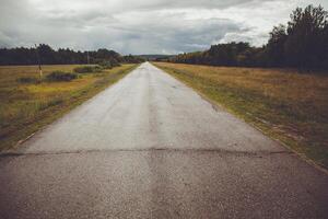 A long empty road in the middle of a field photo