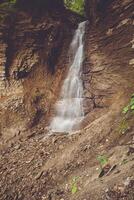 A man standing next to a waterfall with a camera photo