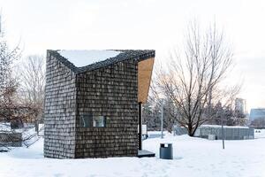 A small cabin in the snow with trees in the background photo