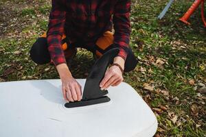 A person is using a knife to cut a surfboard photo