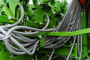 A close up of a green tractor with many hoses photo