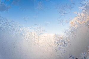 Frost on a window with blue sky in the background photo