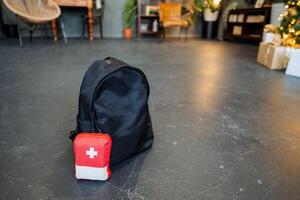 A backpack and a red cross on the floor photo