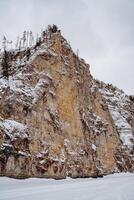 A snowy mountain side with a cliff photo