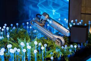 A robot is sitting on a table with plants and lights photo