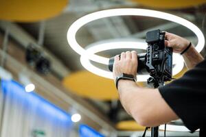 A man holding a camera in front of a circular light photo