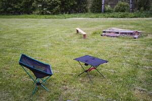 Two chairs and a table in a field photo