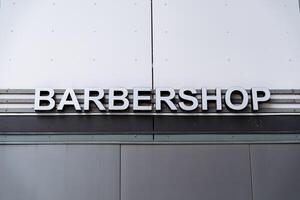 A sign that says barber shop on the side of a building photo