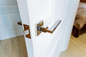 A white door with a handle and a door knob photo