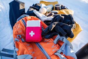 A backpack with a first aid kit on top of it photo
