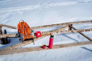 A backpack and a water bottle on a wooden bridge photo