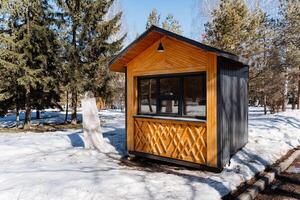 A small cabin in the snow with trees in the background photo