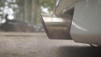 The dual exhaust pipe of a powerful car emitting smoke. Footage. Exhaust fumes and pollution. Close-up and slow motion. Engine working. Air pollution. video