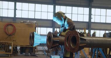 An Industrial Worker Wearing Protective Gear in a Workshop Environment While Working. Media video