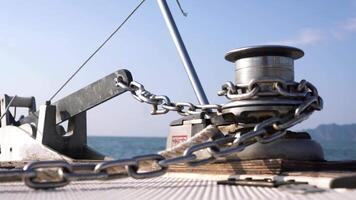 View from the deck of the boat, close-up of the anchor chain and stand for the sea rope. Footage. The boat moves up and down on the wavy ocean. video