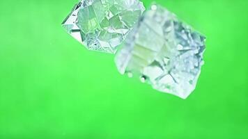 Chunks of ice shimmer as they drop from above. Green screen chromakey video