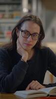 A Focused Reader Engrossed in Books while Calmly Exploring Knowledge in a Library Setting video
