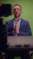 A professional man is actively speaking to the camera while positioned on a green screen set video