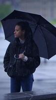 A Reflective Moment in the Rain Holding an Umbrella Surrounded by a Cloudy Background video