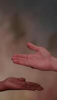 This artwork features an open hand gesture set against a vibrant abstract background video